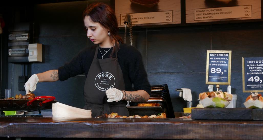 A woman is working in the kitchen at a restaurant 