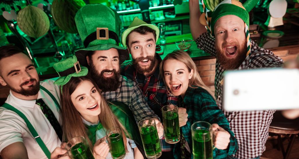 St. Patrick's Day group selfie at a bar with green beer