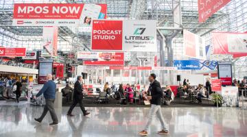 Conference attendees walk past banners at New York's Javits Center