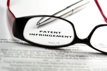 patent infringement paperwork with glasses and pen