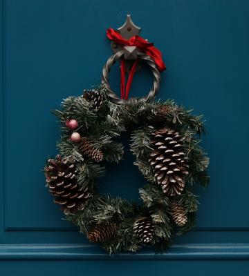 A blue door with a holiday wreath hanging