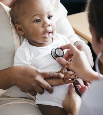 A baby is being seen by a doctor
