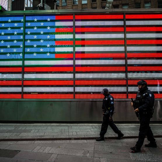 Police officers walking in front of U.S. flag