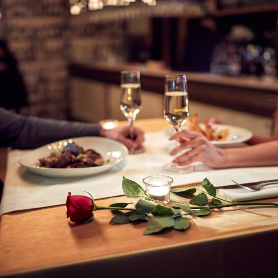 Couple on a romantic dinner date together with wine and food