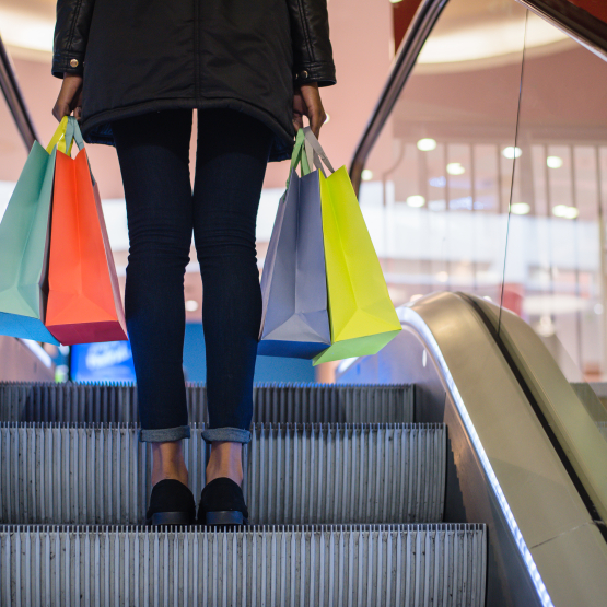 a woman is shown on the escalator with shopping bags