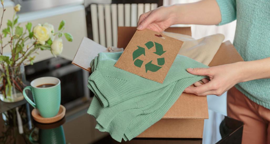 Box of clothing and recycle sign.