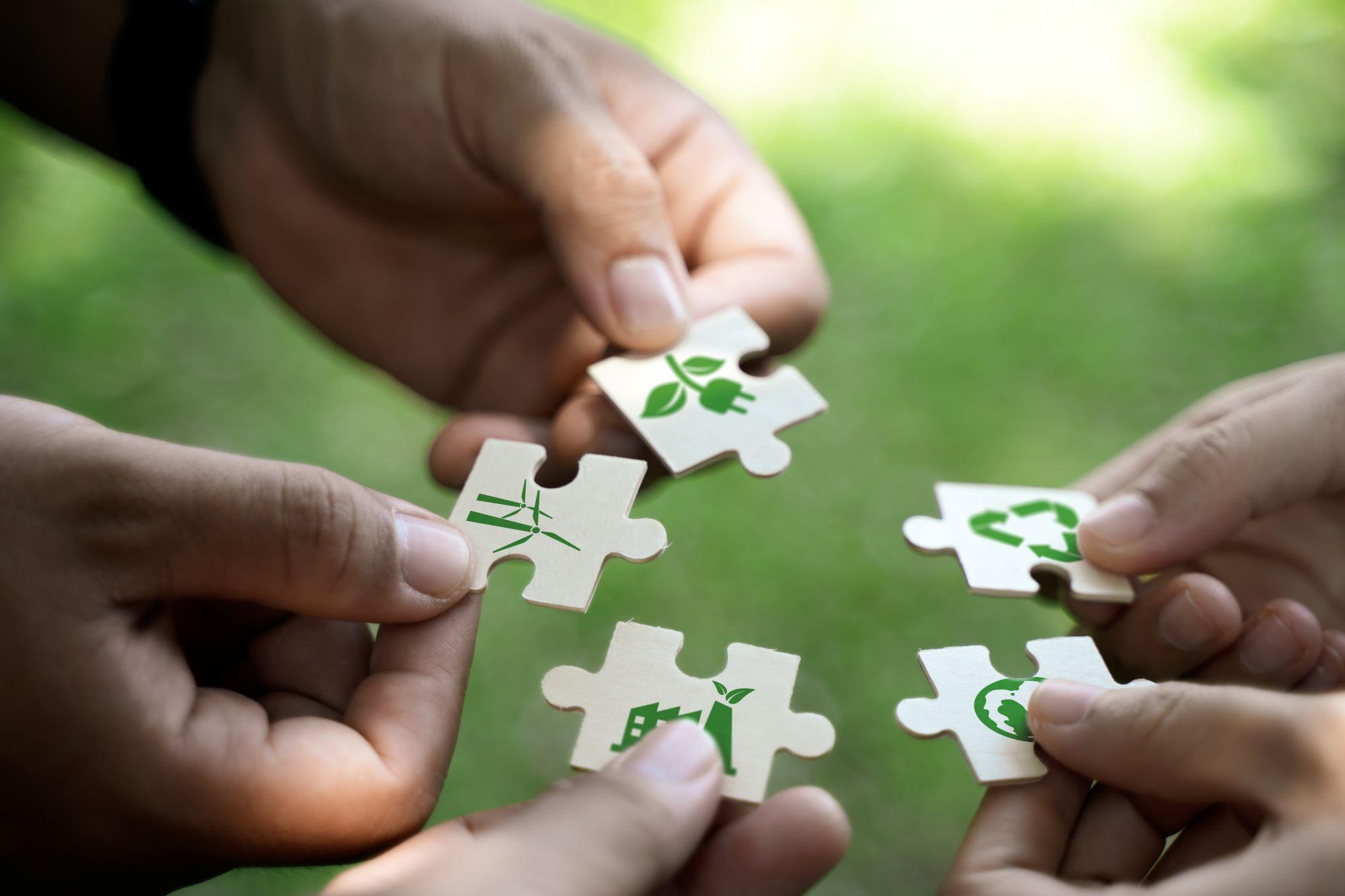 Puzzle pieces with sustainability symbols.