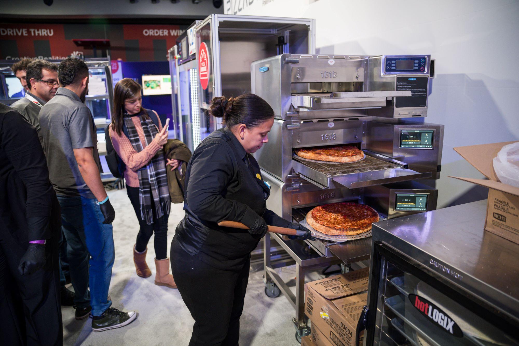 A woman making pizzas at NRF's Foodservice Innovation Zone.