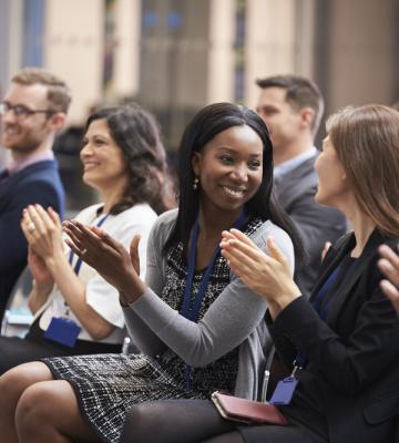 Professionals clapping at a conference.