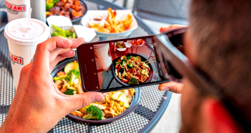 a customer takes a picture of his food from Teriyaki Madness