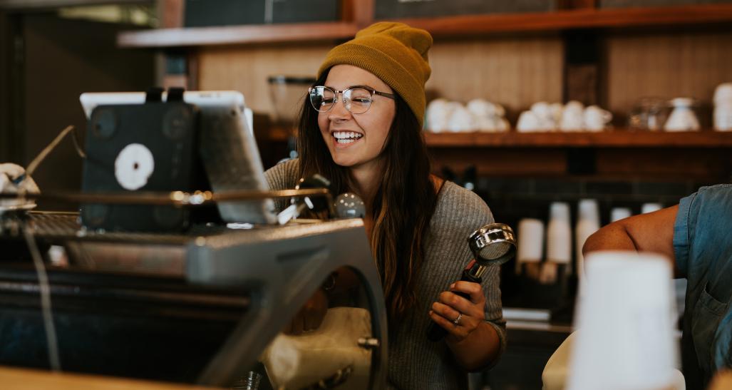 cashier smiling as she rings something in the register