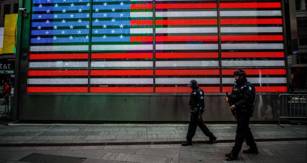 Police officers walking in front of U.S. flag