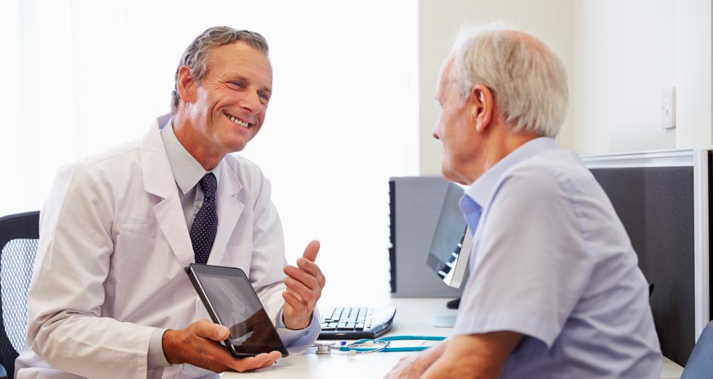 doctor and patient smile and look at screen together during visit