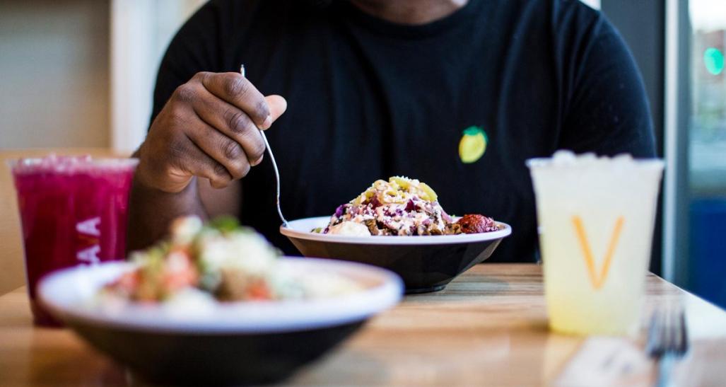 Man eating from rice bowl at restaurant