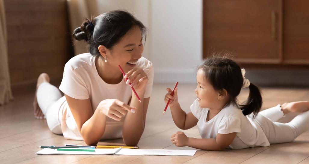 Mother draws with daughter on the floor on Mother's Day