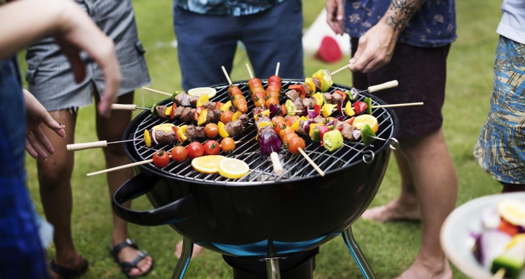 A group of people around a charcoal grill