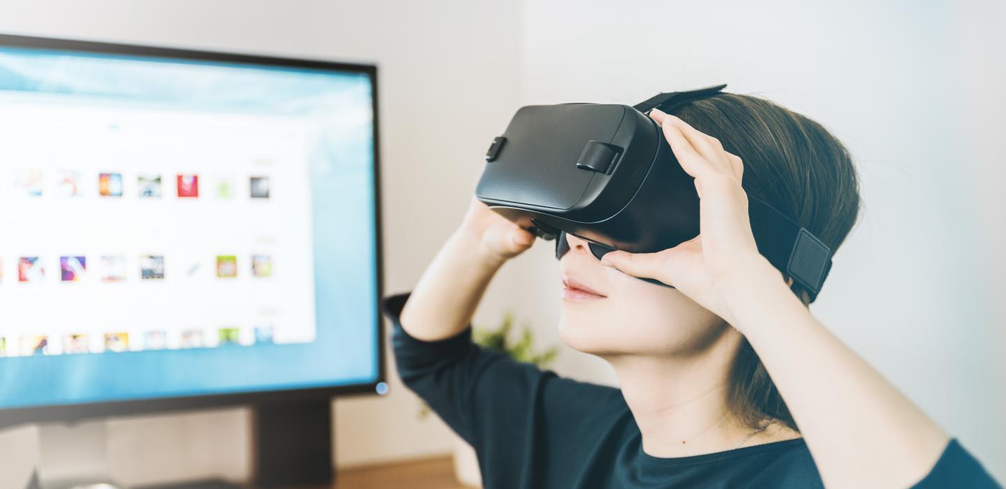 a woman has a headset on while viewing something via virtual reality
