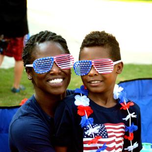 A son sits on his mom's lap for the Independence day celebration