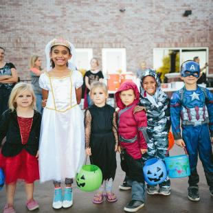 A group on children on halloween holding their candy baskets