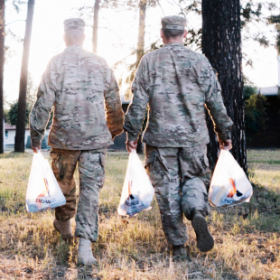 Military men walking with groceries