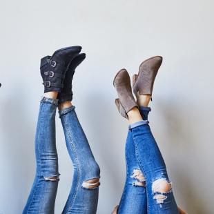 three women with their legs up show off their shoes from DSW