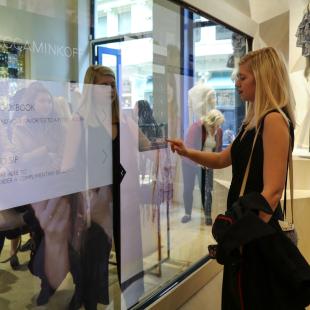 Woman in front of touch screen mirror at Rebecca Minkoff