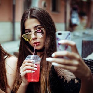 Teenage girls with drinks taking a selfie