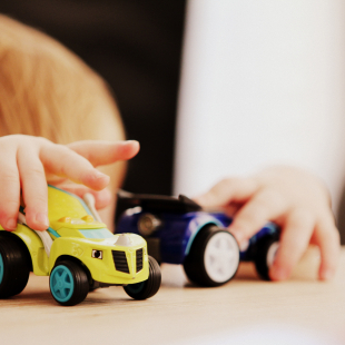 two car toys being played with by a little kid