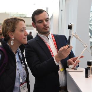 nrf 2018 innovation lab guy displays a technology device to a retailer