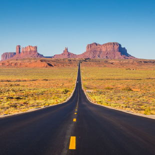 An open road with mountain ranges in Utah. 