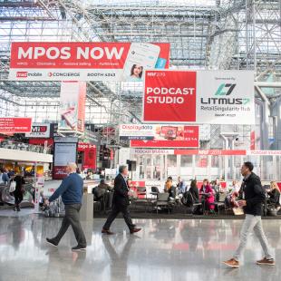 Conference attendees walk past banners at New York's Javits Center