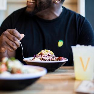 Man eating from rice bowl at restaurant