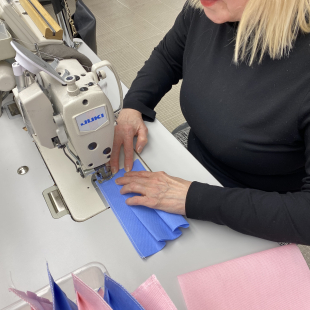 Woman sews masks at sewing machine