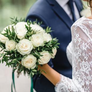 Wedding couple with bouquet of white roses