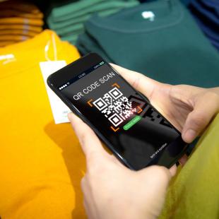 Woman scans a QR code on a clothing label while shopping