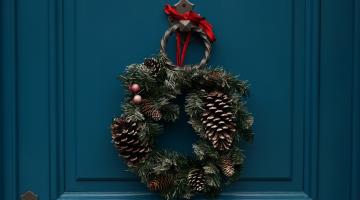 A blue door with a holiday wreath hanging