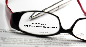 patent infringement paperwork with glasses and pen
