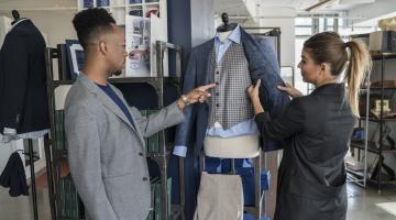 Customer and fashion store assistant choosing a suit