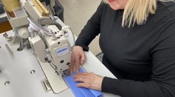 Woman sews masks at sewing machine