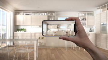A person holds up a smartphone in their home