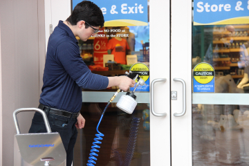 A man cleans doors of a store
