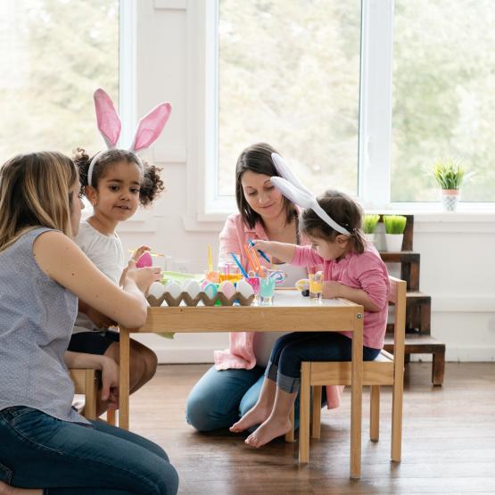 a family is shown with friends painting easter eggs