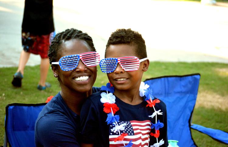 A son sits on his mom's lap for the Independence day celebration