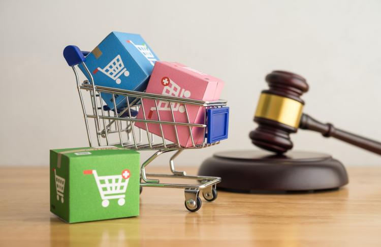 A shopping cart and gavel symbolizing retail law. 